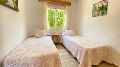 a bedroom with two beds and a window at Casa Juan in Conil de la Frontera