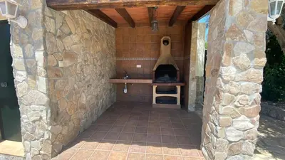 a stone walled outdoor kitchen with a pizza oven at Casa Juan in Conil de la Frontera