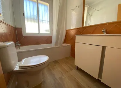a bathroom with a toilet and a sink and a tub at Casa Juan in Conil de la Frontera