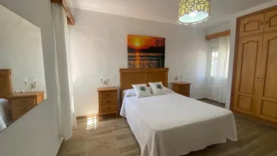 a bedroom with a white bed with two pillows on it at Casa Juan in Conil de la Frontera
