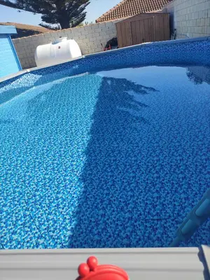 a blue swimming pool with a red fire hydrant next to it at Casita de madera Azul in Chiclana de la Frontera