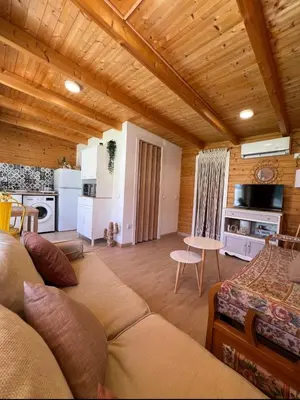 a living room with a couch and a kitchen at Casita de madera Azul in Chiclana de la Frontera