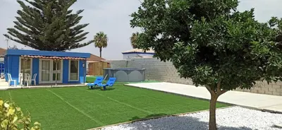a yard with a blue bench and a house at Casita de madera Azul in Chiclana de la Frontera