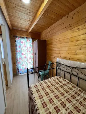 a bedroom with a bed and a wooden wall at Casita de madera Azul in Chiclana de la Frontera