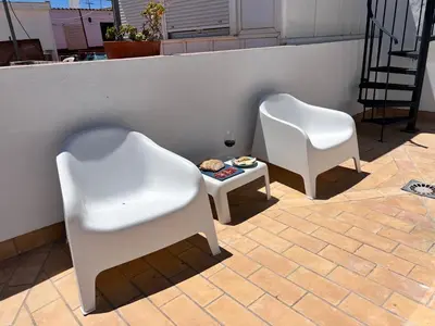 two white chairs and a table on a patio at Ático Castillo by Summerland Rota in Rota