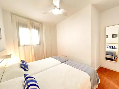 a bedroom with two beds and a window at Ático Castillo by Summerland Rota in Rota