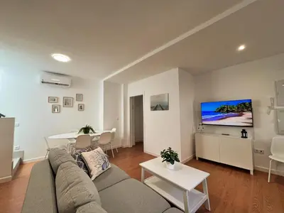 a living room with a couch and a table at Ático Castillo by Summerland Rota in Rota