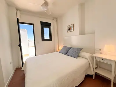 a bedroom with a white bed and a window at Ático Castillo by Summerland Rota in Rota