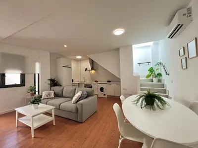 a living room with a couch and a table at Ático Castillo by Summerland Rota in Rota