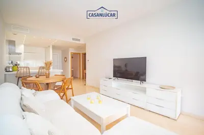 a living room with a white couch and a table at Apartamento Soto Verde in Sanlúcar de Barrameda