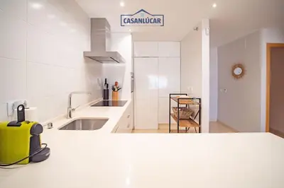 a kitchen with a yellow suitcase sitting on a counter at Apartamento Soto Verde in Sanlúcar de Barrameda