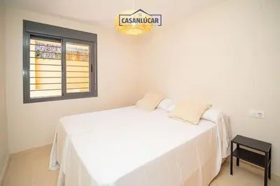 a bedroom with a white bed and a window at Apartamento Soto Verde in Sanlúcar de Barrameda