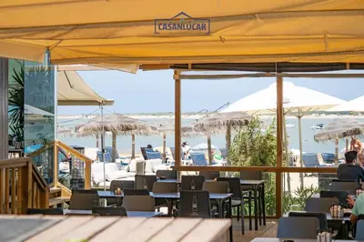 a restaurant with tables and chairs and umbrellas at Apartamento Soto Verde in Sanlúcar de Barrameda