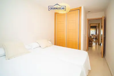 a bedroom with a white bed and a sign that readscussion at Apartamento Soto Verde in Sanlúcar de Barrameda