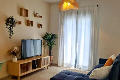 a living room with a tv and a blue couch at Dúplex Chiclana Centro con Terraza y Parking By Chiclana Dreams in Chiclana de la Frontera