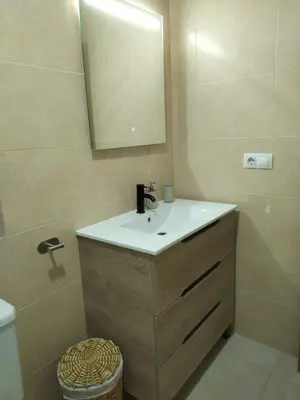 a bathroom with a sink and a mirror and a toilet at Dúplex Chiclana Centro con Terraza y Parking By Chiclana Dreams in Chiclana de la Frontera