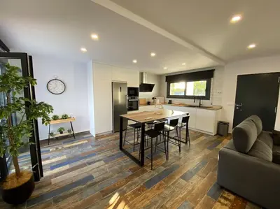 a kitchen and living room with a table and a couch at Villa Romance in Chipiona