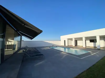 a kitchen and a swimming pool with chairs next to a house at Villa Romance in Chipiona