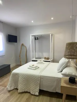 a bedroom with a white bed with two towels on it at Apartamentos Corredera 4 in Arcos de la Frontera