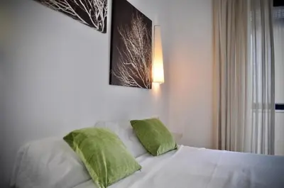 a bedroom with a bed with two green pillows at Apartamento en Casa Palacio- Centro Sanlucar in Sanlúcar de Barrameda