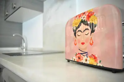 a appliance with a painting of a woman on it on a kitchen counter at Apartamento en Casa Palacio- Centro Sanlucar in Sanlúcar de Barrameda
