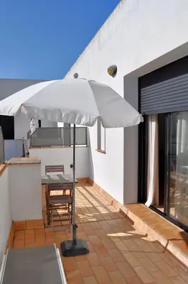 a patio with a table and an umbrella at Apartamento en Casa Palacio- Centro Sanlucar in Sanlúcar de Barrameda