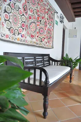 a bench in a room with a painting on the wall at Apartamento en Casa Palacio- Centro Sanlucar in Sanlúcar de Barrameda