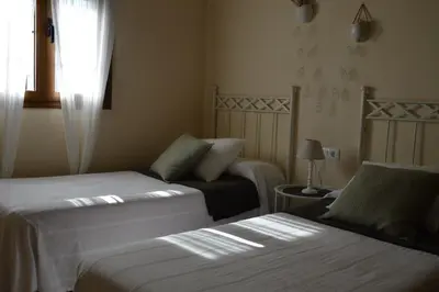 a hotel room with two beds and a window at Las Yucas in Conil de la Frontera