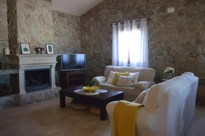 a living room with a couch and a tv and a fireplace at Las Yucas in Conil de la Frontera