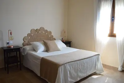 a bedroom with a large bed and a window at Las Yucas in Conil de la Frontera