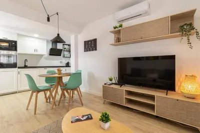 a living room with a large television and a table at Allo Apartments Morenos V Centro Gran Terraza in Jerez de la Frontera