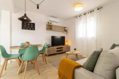 a living room with a couch and a table at Allo Apartments Morenos V Centro Gran Terraza in Jerez de la Frontera