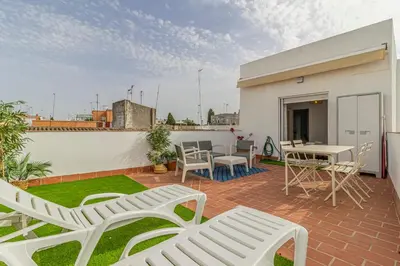 a patio with white chairs and a table on a roof at Allo Apartments Morenos V Centro Gran Terraza in Jerez de la Frontera