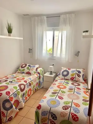 a bedroom with two beds and a window at Oasis Flamencos Golf in Sanlúcar de Barrameda
