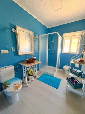 a blue bathroom with a toilet and a sink at El rincón de Nai in Chiclana de la Frontera