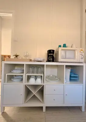 a white cabinet with a microwave on top of it at El rincón de Nai in Chiclana de la Frontera