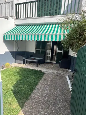 a green awning on the side of a building at Apartamento Las Arenas in Chiclana de la Frontera