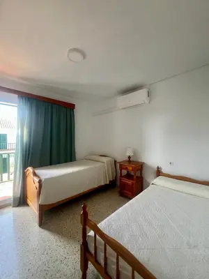a bedroom with two beds and a window at Apartamento Las Arenas in Chiclana de la Frontera