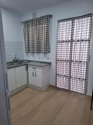 a kitchen with a sink and a counter and curtains at Apartamento Las Arenas in Chiclana de la Frontera