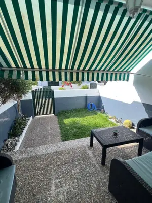 a patio with a green and white striped canopy at Apartamento Las Arenas in Chiclana de la Frontera