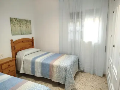 a bedroom with two beds and a window at Casa Elena in Conil de la Frontera