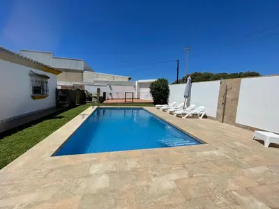 a swimming pool in the backyard of a house at Casa Elena in Conil de la Frontera