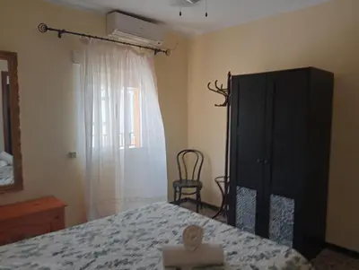 a bedroom with a bed and a dresser and a window at Casa Lomas in Arcos de la Frontera