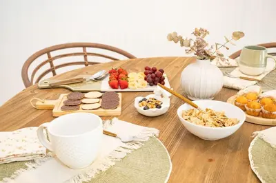 a wooden table with breakfast foods and cups on it at Sanlucar Centro - Apartamento 1 in Sanlúcar de Barrameda
