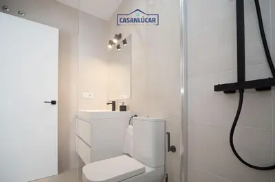 a white bathroom with a toilet and a sink at Sanlucar Centro - Apartamento 1 in Sanlúcar de Barrameda