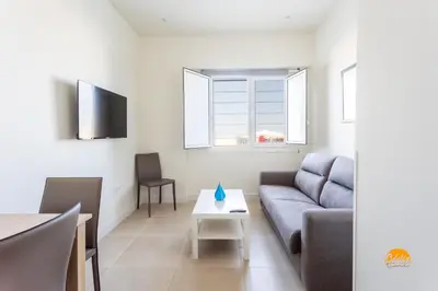 a living room with a couch and a table at Delfin Azul 2 FREE PARKING by Cadiz Time in Cádiz