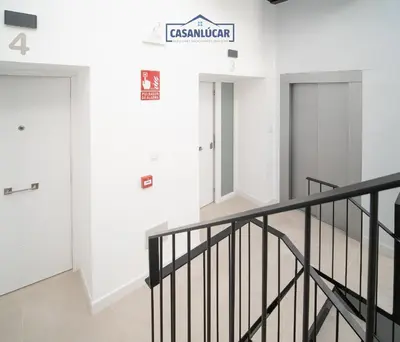 a staircase in a building with a sign on the wall at Sanlucar Centro - Apartamento 2 in Sanlúcar de Barrameda