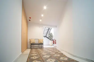 a hallway with a rug and a chair and a window at Sanlucar Centro - Apartamento 3 in Sanlúcar de Barrameda
