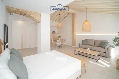 a living room with a white bed and a couch at Sanlucar Centro - Apartamento 4 in Sanlúcar de Barrameda