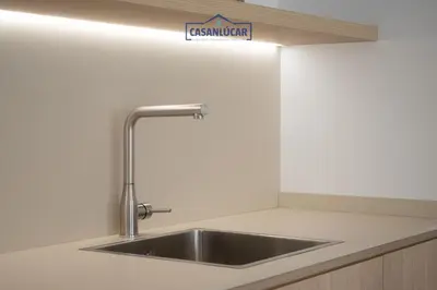a sink in a kitchen with a sign on the wall at Sanlucar Centro - Apartamento 4 in Sanlúcar de Barrameda